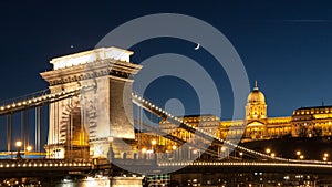 Illuminated Buda Castle and detailed view of Chain Bridge over Danube River in Budapest by night, Hungary