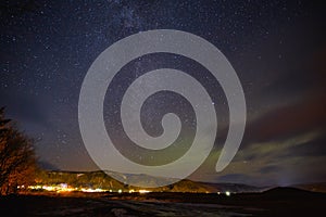 illuminated buildings and beautiful starry sky with northern lights