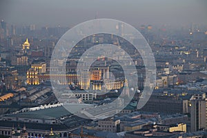 Illuminated buildings and roofs in fog at summer photo