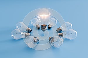 Illuminated Bulb In Circle of Unlit Light Bulbs