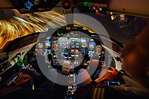 Illuminated Businessjet Cockpit at night during a turn