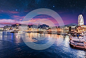 Illuminated Cape Town waterfront at night with stars in the sky