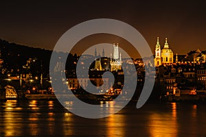 Illuminated Charles Bridge,Karluv most reflected in Vltava River. Evening panorama of Prague, Czech Republic. Long exposure city