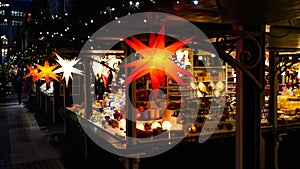 Illuminated Christmas fair kiosk with loads of shining decoration merchandise
