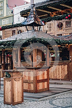 Illuminated Christmas fairground with wooden kiosk with a lot of bright decorations, without logos