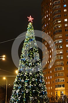 Illuminated Christmas tree and high-rise house