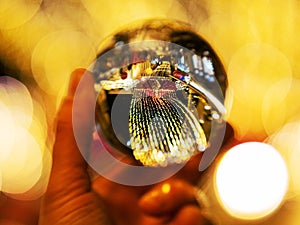 Illuminated city lights in a glass ball, selective focus. Special season or event decoration and celebration