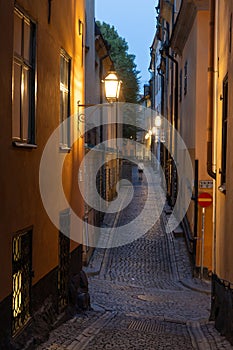 Illuminated cobbled street in the old town of Stockholm, Sweden at dusk