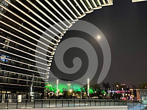 Illuminated Culture Plaza in Changzhou China with the full moon shining in the sky in the background