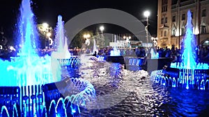 Illuminated fountain in the city square at night