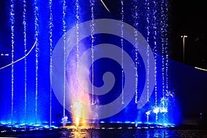 Illuminated fountain at night. Light and water show.
