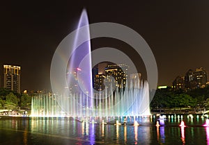 Illuminated fountain at night in modern city