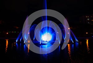 The illuminated fountain at night on the pond