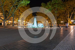 Illuminated fountain and tree lined promenade long exposure nigh