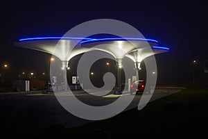 Illuminated futuristic gas station at night