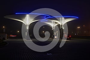 Illuminated futuristic gas station at night