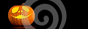 Illuminated Halloween Jack-o-lantern pumpkin black panoramic background with copy space