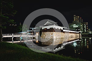 The illuminated Hiroshima castle with bridge surrounded by water in the night, Hiroshima, Japan