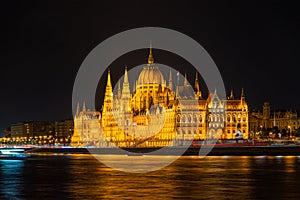 Illuminated historical building of Hungarian Parliament at night on Danube River Embankment.