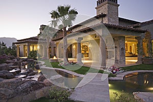 Illuminated House With Pond In Foreground