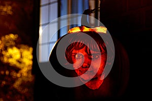 Illuminated jack o` lantern carved with the design of a child`s face