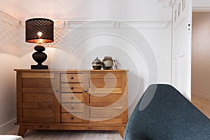 Illuminated lamp on sideboard buffet in living room photo