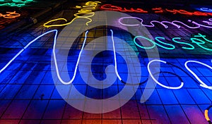 Illuminated letters and words made with neon lights and blue LEDs of many colors and red and totally black background. Jazz poster