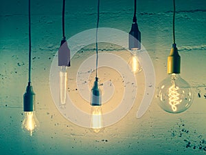 Illuminated light bulbs on green background