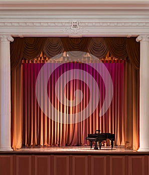 Illuminated by lights stage with backstage and decorative columns, there is an old grand piano