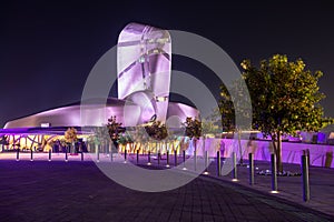 Illuminated modern building and square with trees in the center of Al Khobar, Saudi Arabia