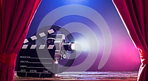 Movie Camera With Clapperboard And Film Reel On Stage photo