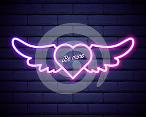 Illuminated neon heart angel wings sign frame light electric banner glowing,black brickwall background.Valentines Day,sex shop,bar