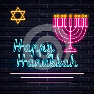 Illuminated neon signs Happy Hanukkah holiday light electric banner glowing on black brickwall.