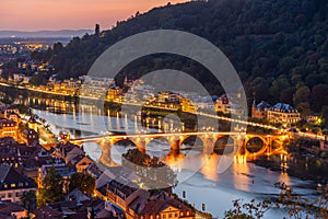 Illuminated old bridge leading to the Holy Spirit church in Heidelberg, Germany