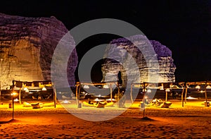 Illuminated outdoor lounge in front of elephant rock erosion monolith standing in the night desert, Al Ula, Saudi Arabia photo