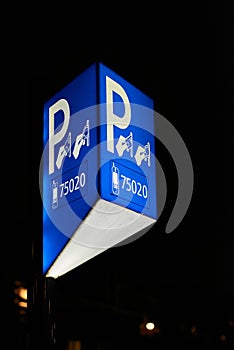 Illuminated parking meter sign in the evening