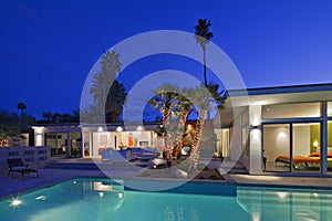 Illuminated patio at poolside in luxurious villa at night