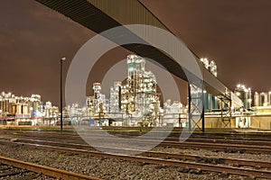 Illuminated petrochemical production plant with train tracks in front, Antwerp, Belgium