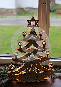 Illuminated plywood Christmas tree against the window photo