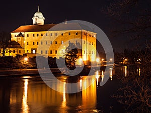 Illuminated Podebrady Castle at Labe River by night, Czech Republic