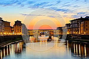 Illuminated Ponte Vecchio with reflections at sunset, Florence, Tuscany, Italy