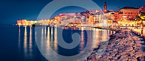 Illuminated quay in Gaeta town with Cathedral Basilica of Gaeta church on background