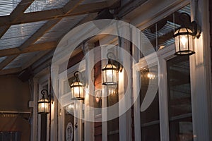 Illuminated rustic lanterns by the windows on the porch