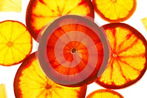 Illuminated slices of citrus fruits on white background