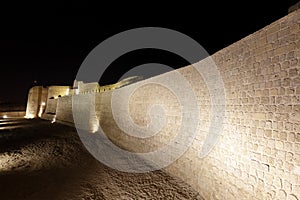 Illuminated Southern wall with moat of Bahrain Fort
