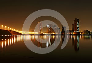 Illuminated street lights and Juffair buildings with reflection, Bahrain