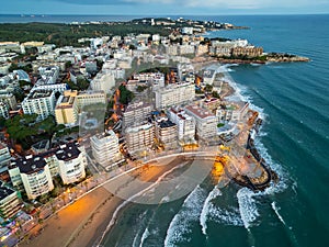 illuminated streets of Spanish touristic city Salou, Catalonia, aerial view of beach, sea and coast with palm trees