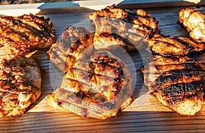 Illuminated by Sunbeams, Grilled Chicken Slices Rest on Wooden Tray, Promising Unmatched Flavor