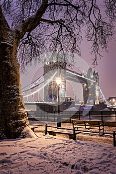 The illuminated Tower Bridge of London on a winter evening with snow and ice