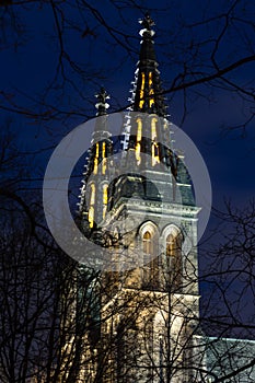 Illuminated towers of the neo gothic basilica of apostles Peter and Paul at Vysehrad castle in Prague at night